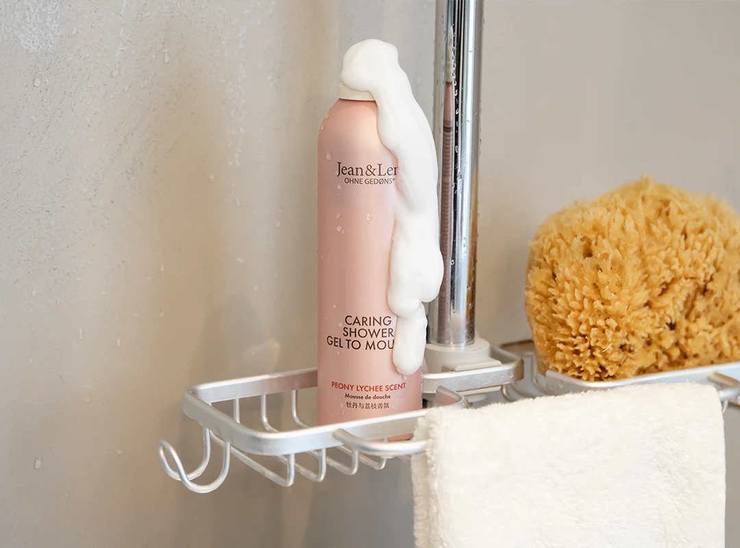 Duschschaum Pfingstrose/Litschi bedeckt mit Schaum steht in einer Duschablage.